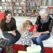 Ans' verjaardag. Vaj&egrave;n geeft een cadeautje. Links Tessa