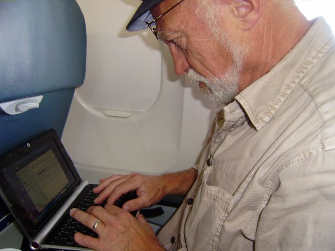 In het vliegtuig typ ik een stukje verslag op mijn nieuwe Packard Bell notebook