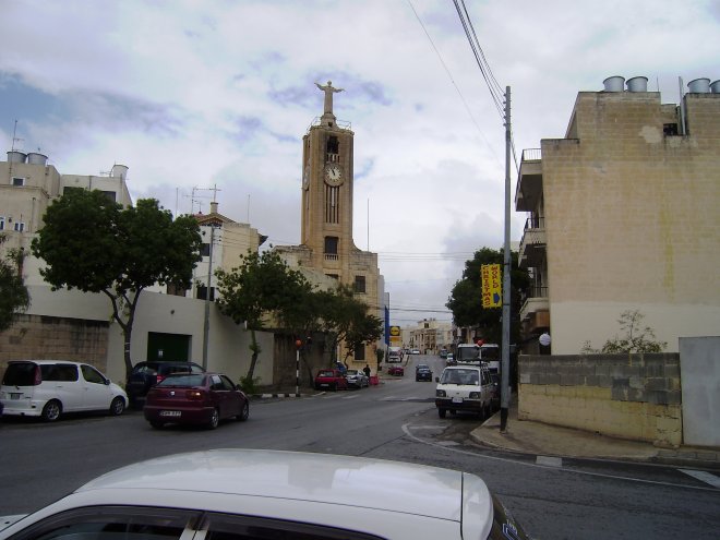 Achter de kerk met het beeld van de heilige Franciscus op de toren ligt de vestiging van de Lidl