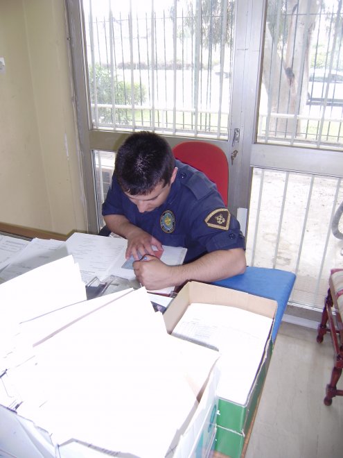 Een jongen van de havenpolitie maakt zuchtend voor ons een cruising permit in orde