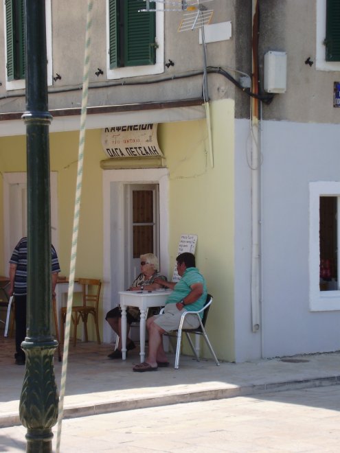 De zwakzinnige jongen in groen shirt zit de hele dag op zijn stoel in het etablissementje tegenover ons. Hier houdt hij de arm van zijn moeder vast