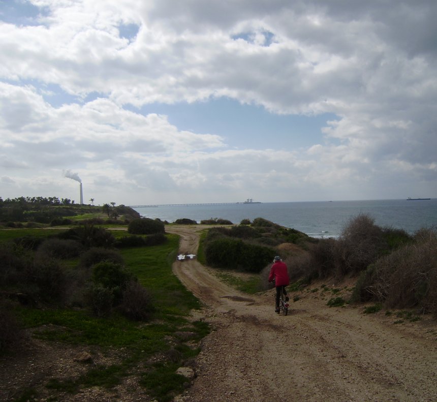 Vanaf de zuidelijke stadswallen van het oude Ashqelon zie je de grote olieterminal. Rechts ligt een tanker te wachten. Er is een bui op komst. Verderop kun je flatgebouwen van Gaza zien (te veraf om op deze foto te zien)