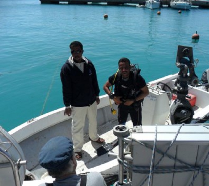 De duiker maakt zich gereed om het onderwaterschip schoon te maken