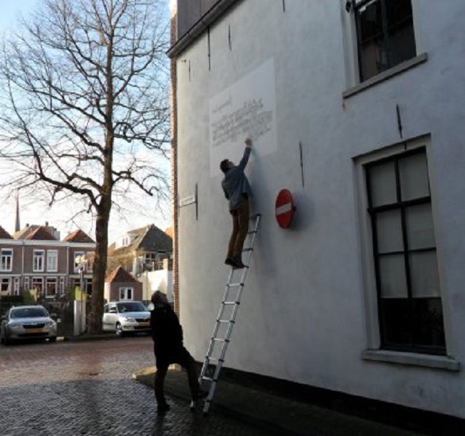 De deskundige onderzoekt het mislukte gedicht op de muur van het huis van Rijk & Joke
