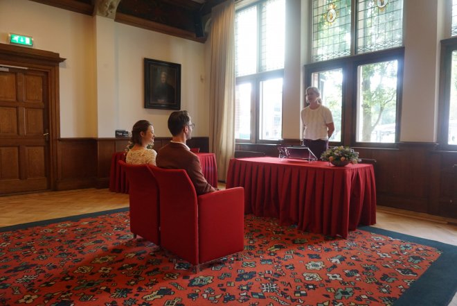 Lois en Rommert voor de trouwambtenaar in het stadhuis van Zeist.