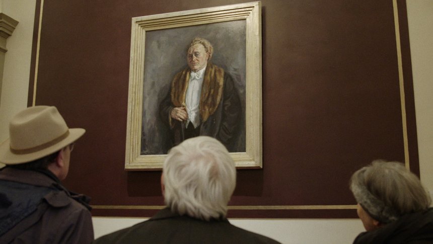 Het portret van Mengelberg, geschilderd door jan Sluyters, in een gang in het Concertgebouw. Still uit de documentaire van de EO. Links staat Paul Brill.