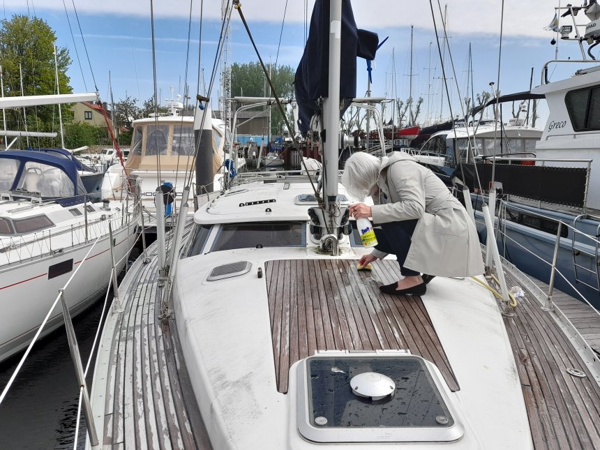 Poetsen op het voordek. Al gauw gaat de regenjas uit.
