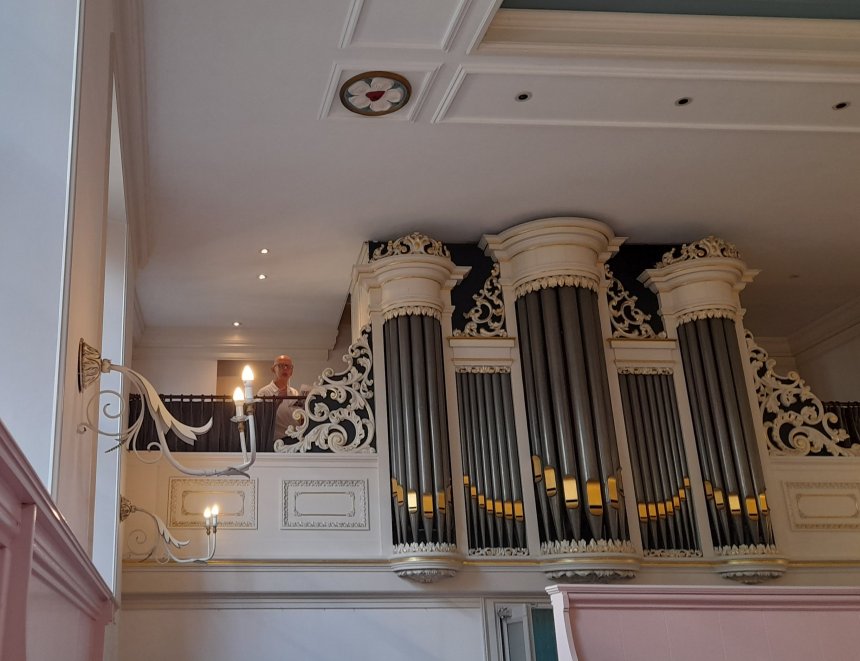 Het Kam-orgel in het schuilkerkje op de Langendijk, met links organist Arjan Versluis.