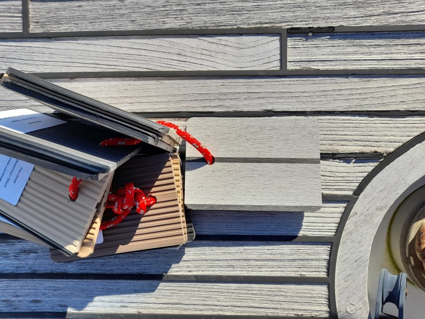 Dit is de kleur die ons kunststof-teakdek krijgt. Je kunt ook zien hoe versleten ons oude teakdek is.