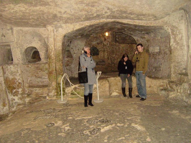 Ans, Esther en Rommert in de St Pauls Catacombs, luisterend naar de audioguide