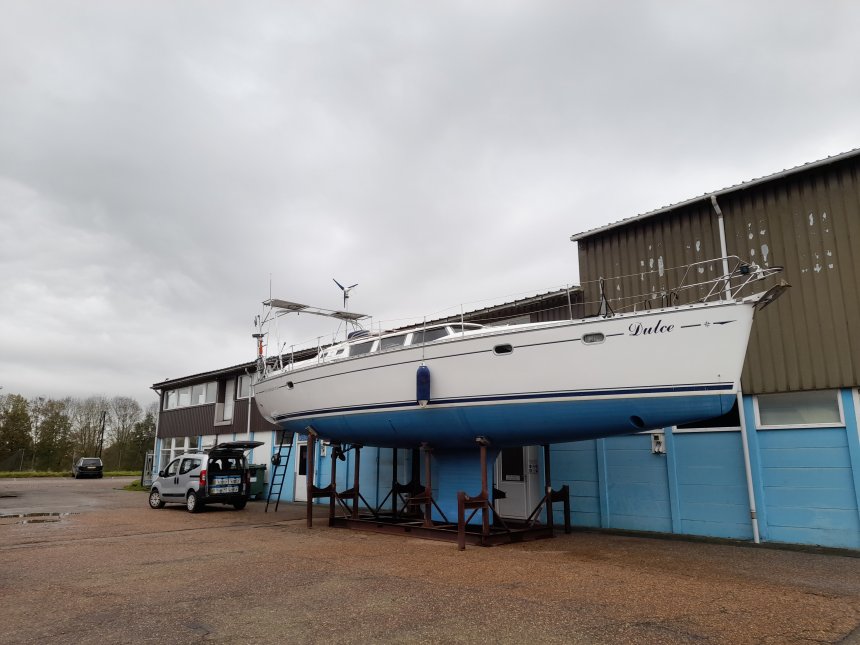 Dulce zonder mast bij de loods van Jachtwerf Rexwinkel in Numansdorp. Het autootje staat erachter.