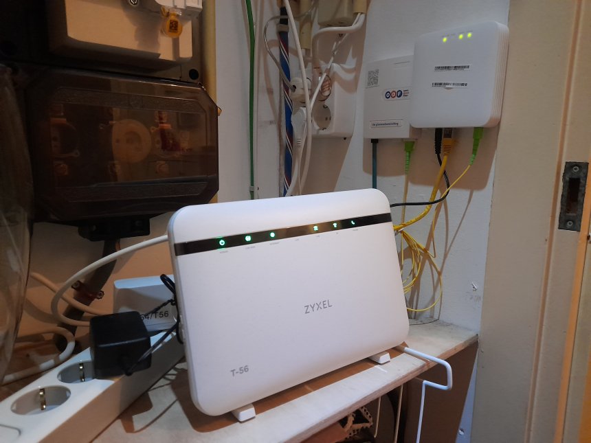 Het Zyxel-WiFi modem van Odido in de meterkast met rechtsboven (links) het kastje waar de glasvezel (blauw) binnenkomt.